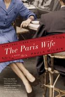 Book Cover The Paris Wife Image of a young woman in a blue dress sitting at an outdoor cafe table.