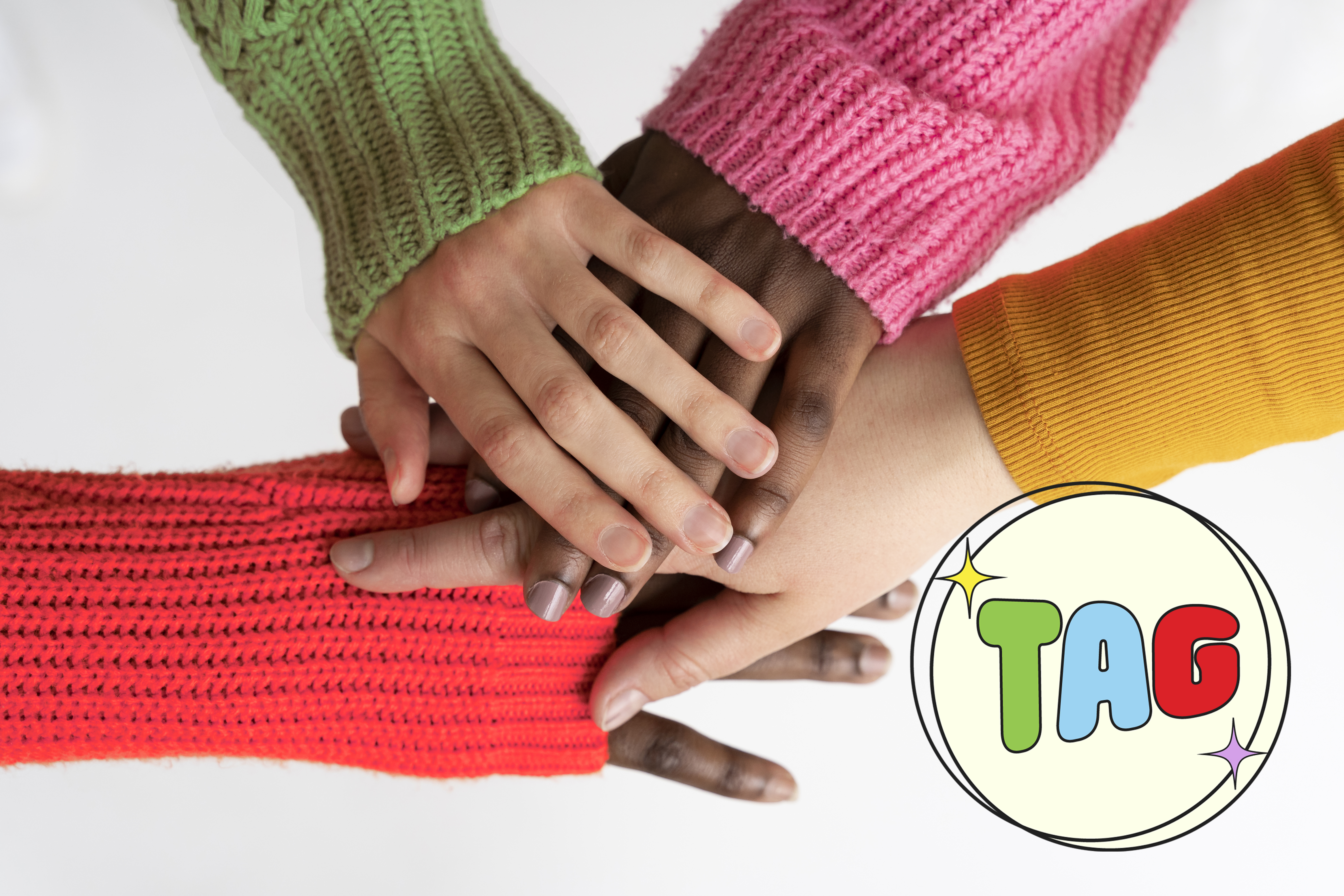 Image of a group of young adults with their hands on top of each other showing solidarity. They're wearing colorful sweaters and text reads "TAG"