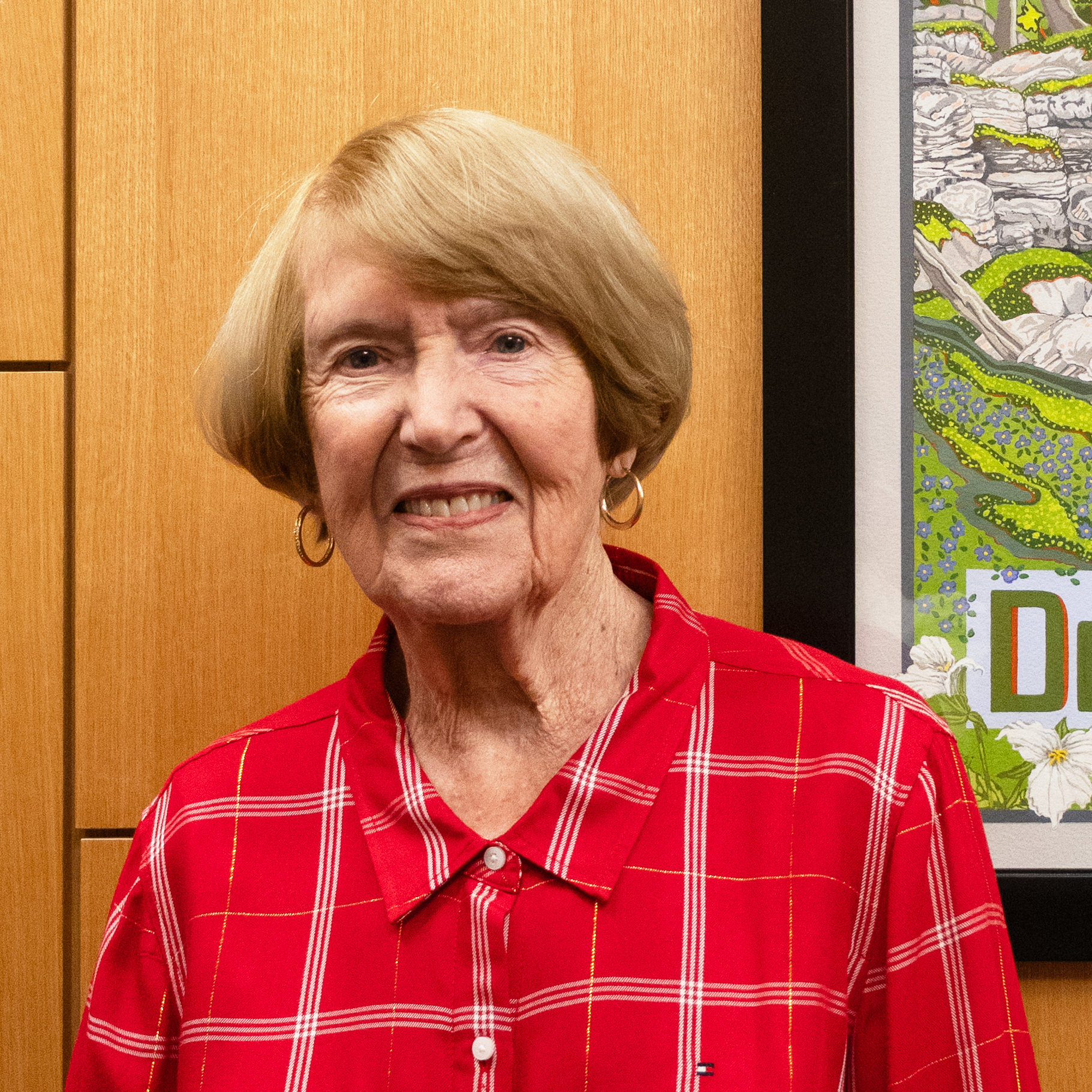 Photo of Pat Peterson our Board Member standing in our cafe smiling at the camera.