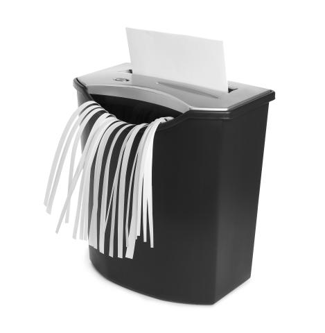 image of a paper shredder that has a piece of paper going in whole and coming out in shreds