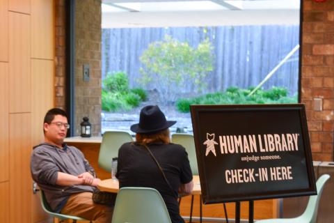 Human Library sign in front of people talking