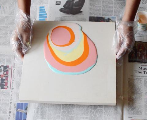 Different colored paints poured over a white canvas. 