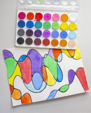 Set of Watercolor paints and a brightly painted picture.