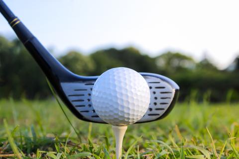 Club swings on golf ball.