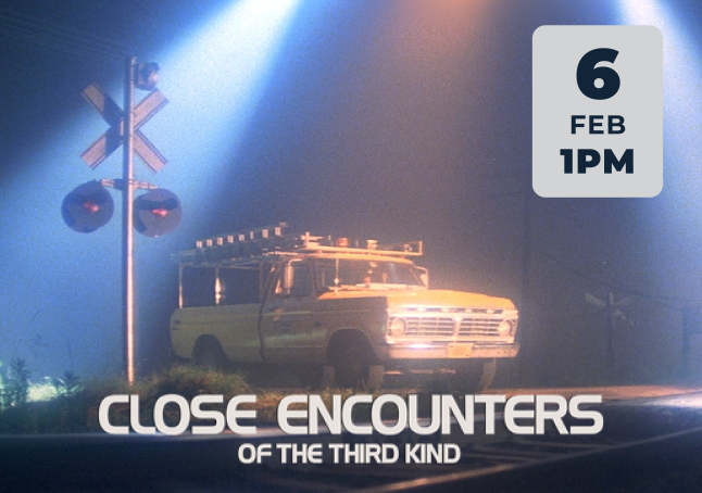 Promotional image of a truck sitting at railroad crossing with bright lights from above