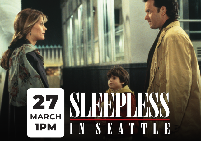 Film still of Meg Ryan and Tom Hanks looking at each other.